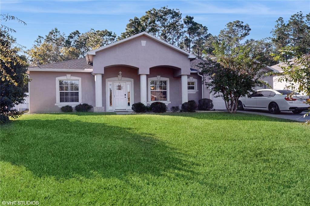 a front view of a house with a yard and trees