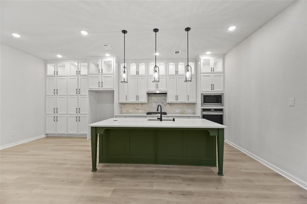 a view of kitchen with kitchen island sink and refrigerator