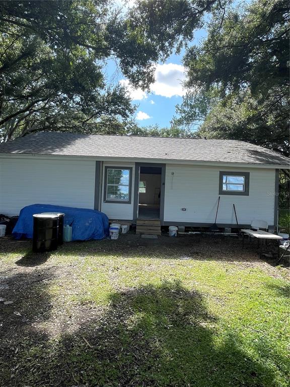 a view of a house with backyard and sitting area