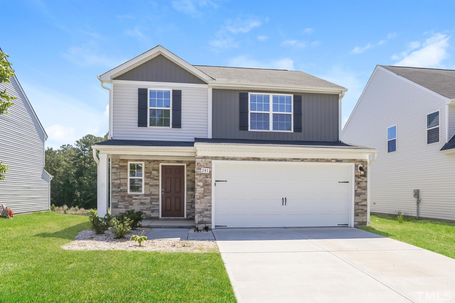 a front view of a house with a yard and garage