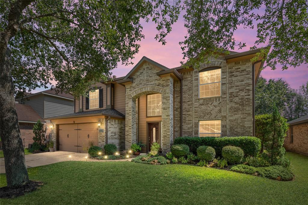 Welcome home to your new two-story brick home with a prominent entrance, tall windows, and an attached two-car garage, nestled among mature trees and well-maintained landscaping with underground lawn sprinkler system.