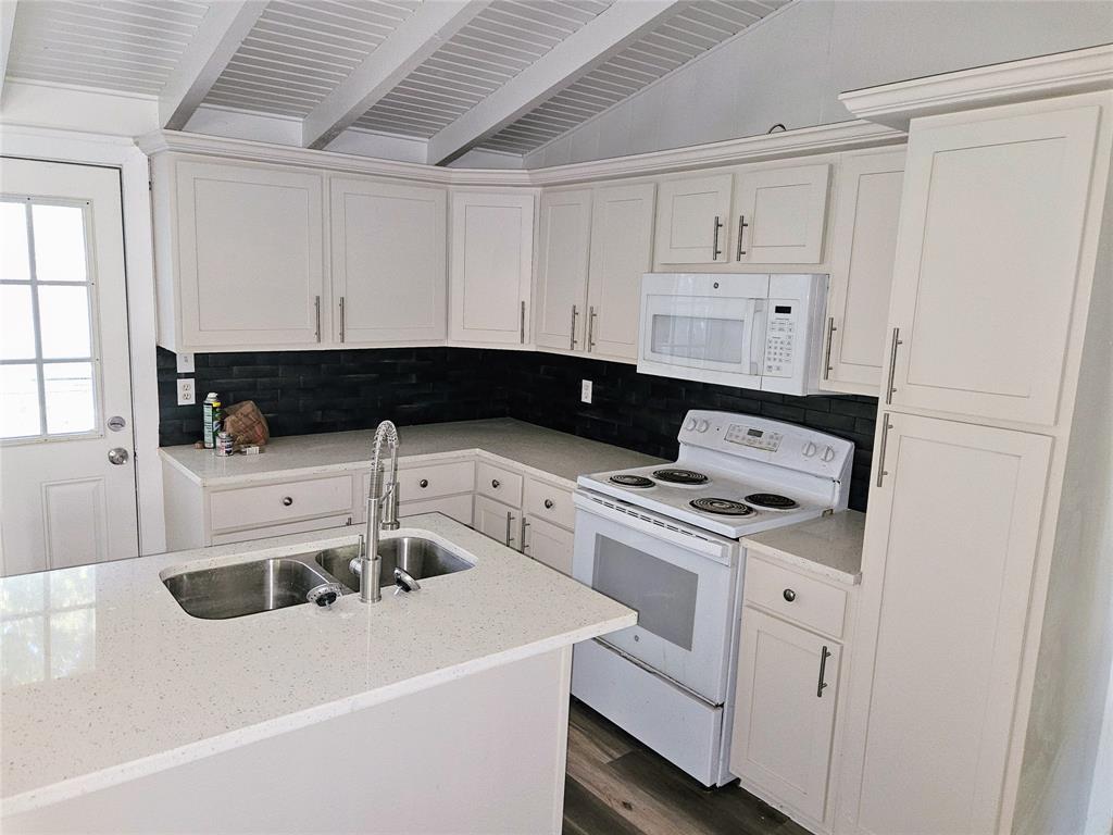 a kitchen with a sink a stove and cabinets