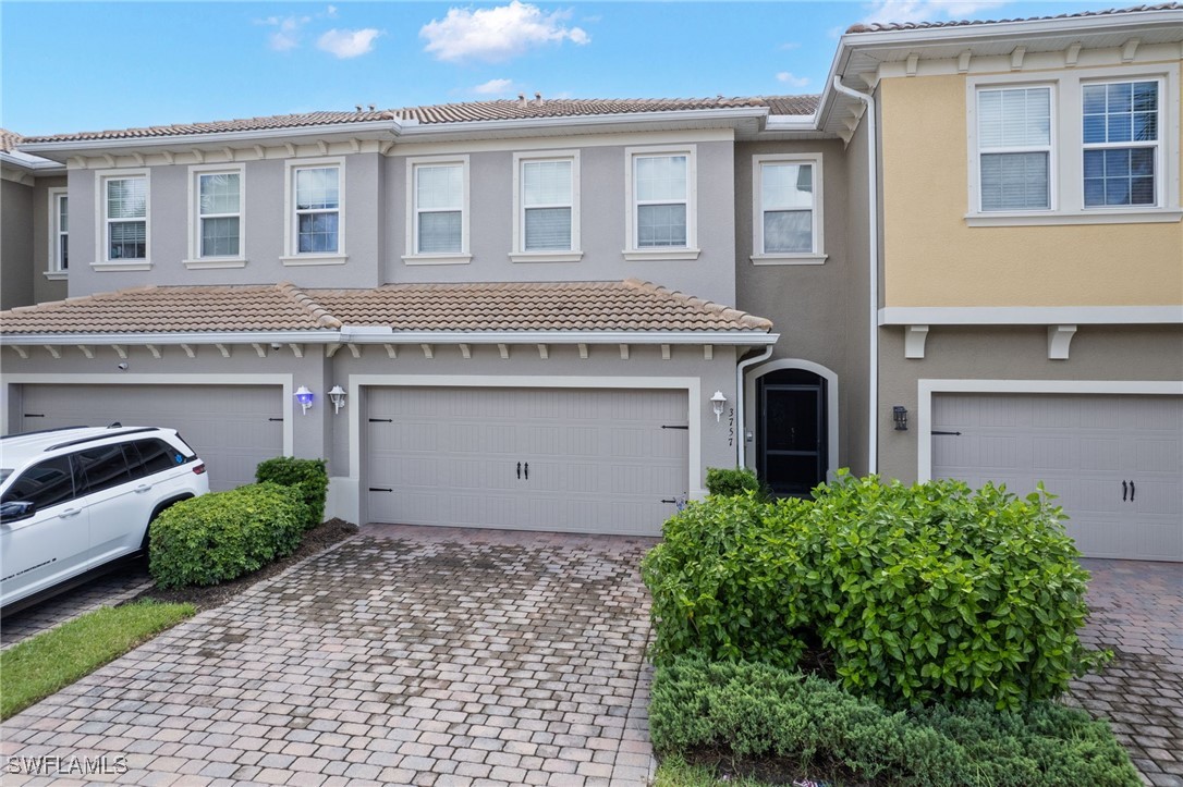 a front view of a house with yard and parking