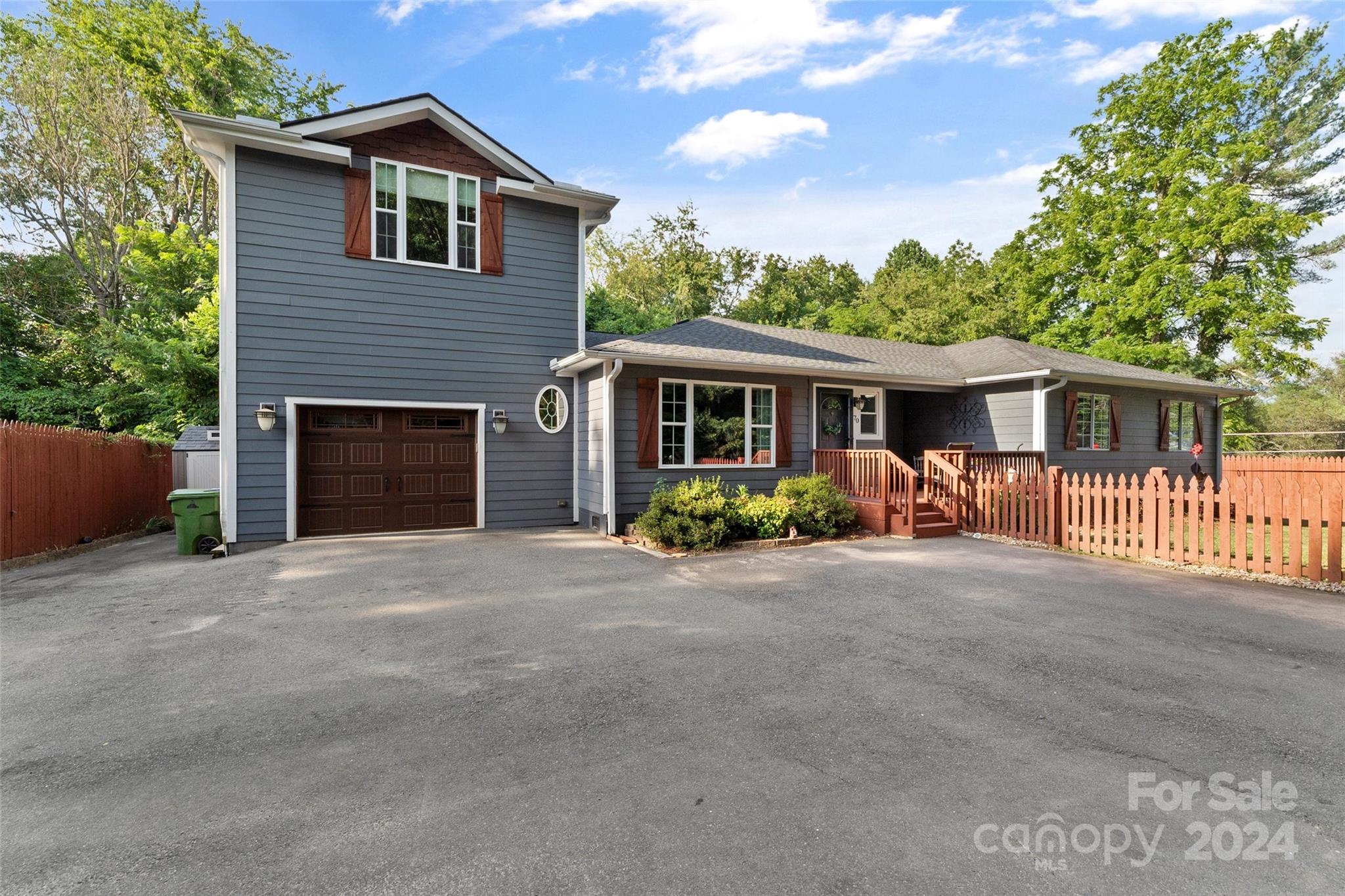 a front view of a house with yard and parking