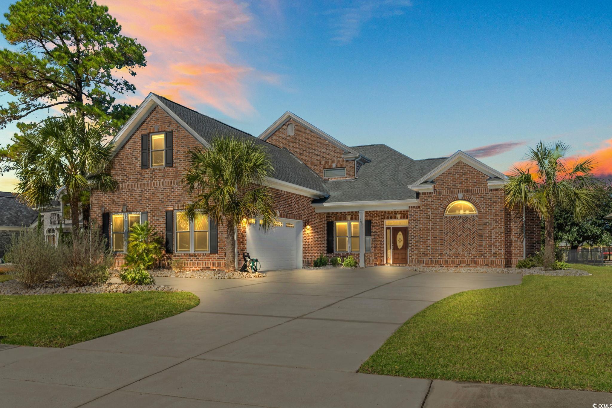 View of front of house with a garage and a yard