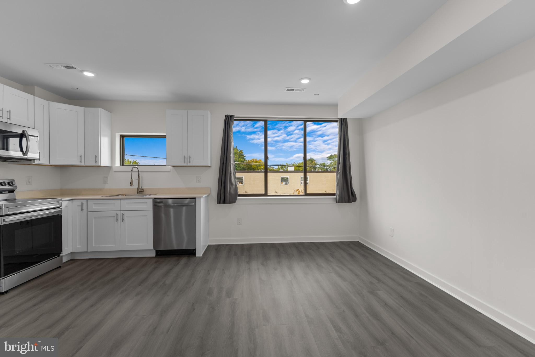 a large kitchen with a wooden floor and a large window