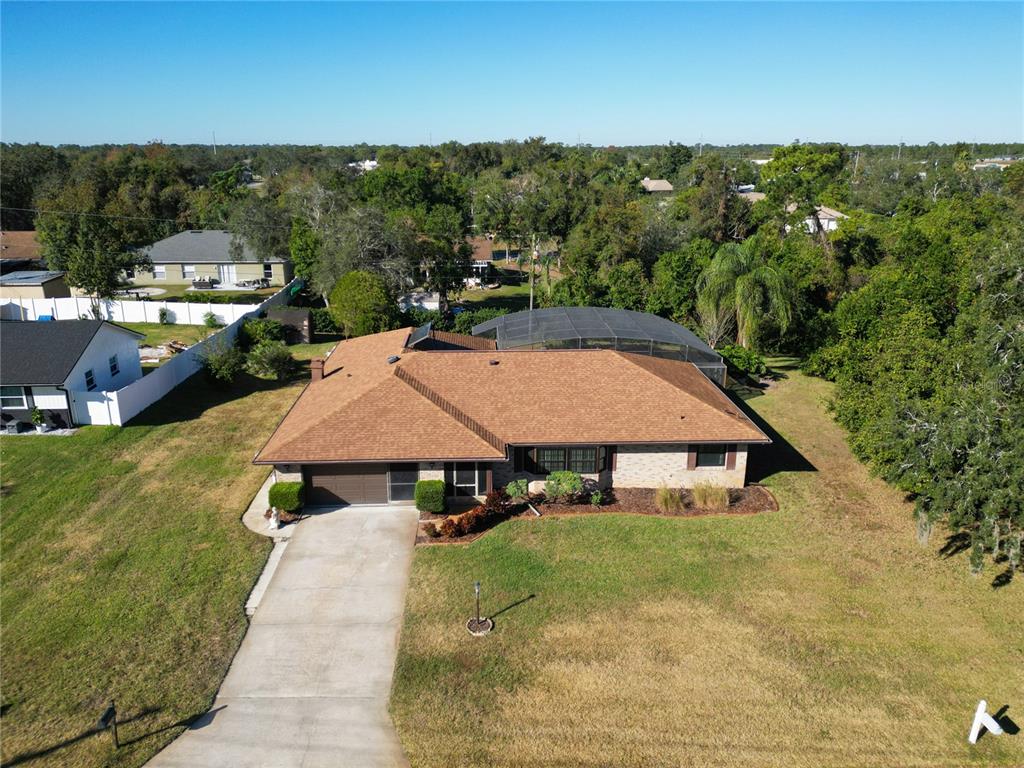 an aerial view of a house with swimming pool and garden