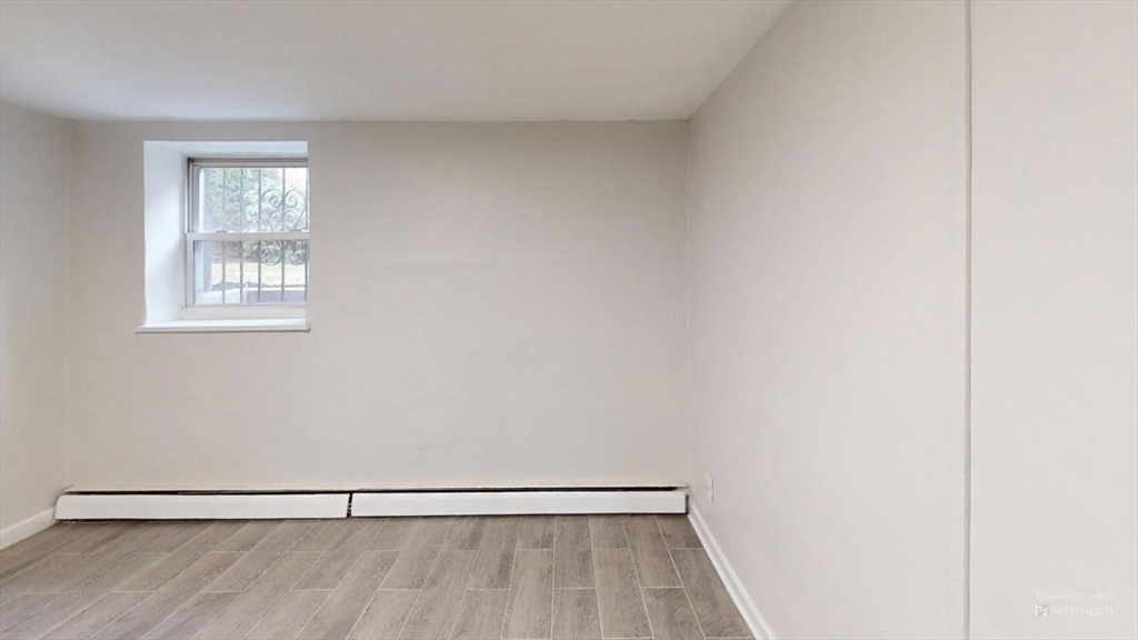 a view of a room with wooden floor and a window