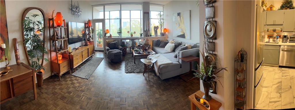 a living room with furniture fireplace and a large window