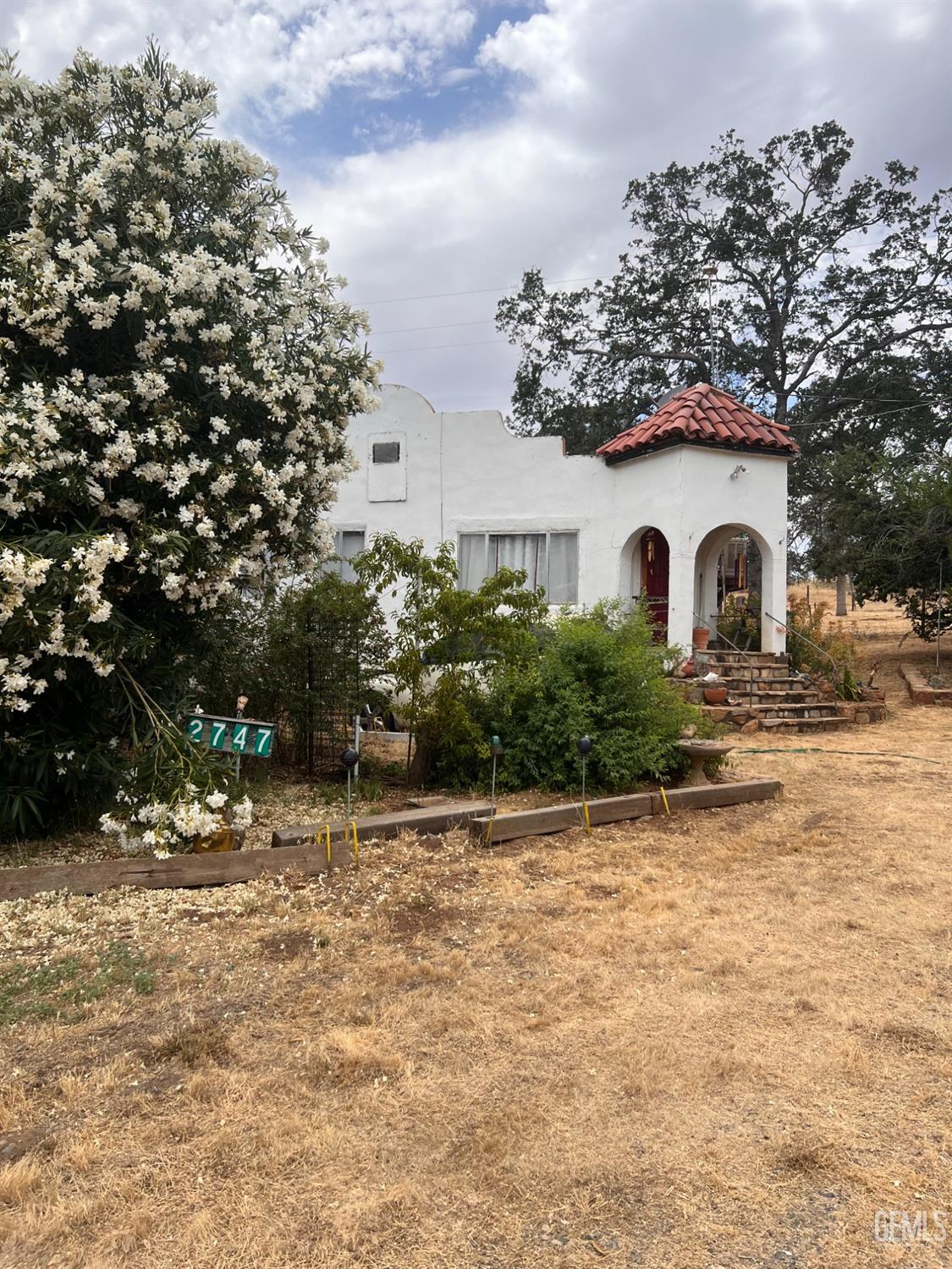 a white house that has a tree in front of it