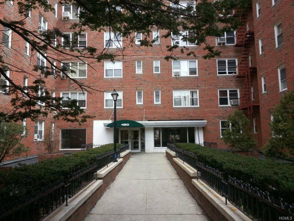 a front view of a residential apartment building with a yard