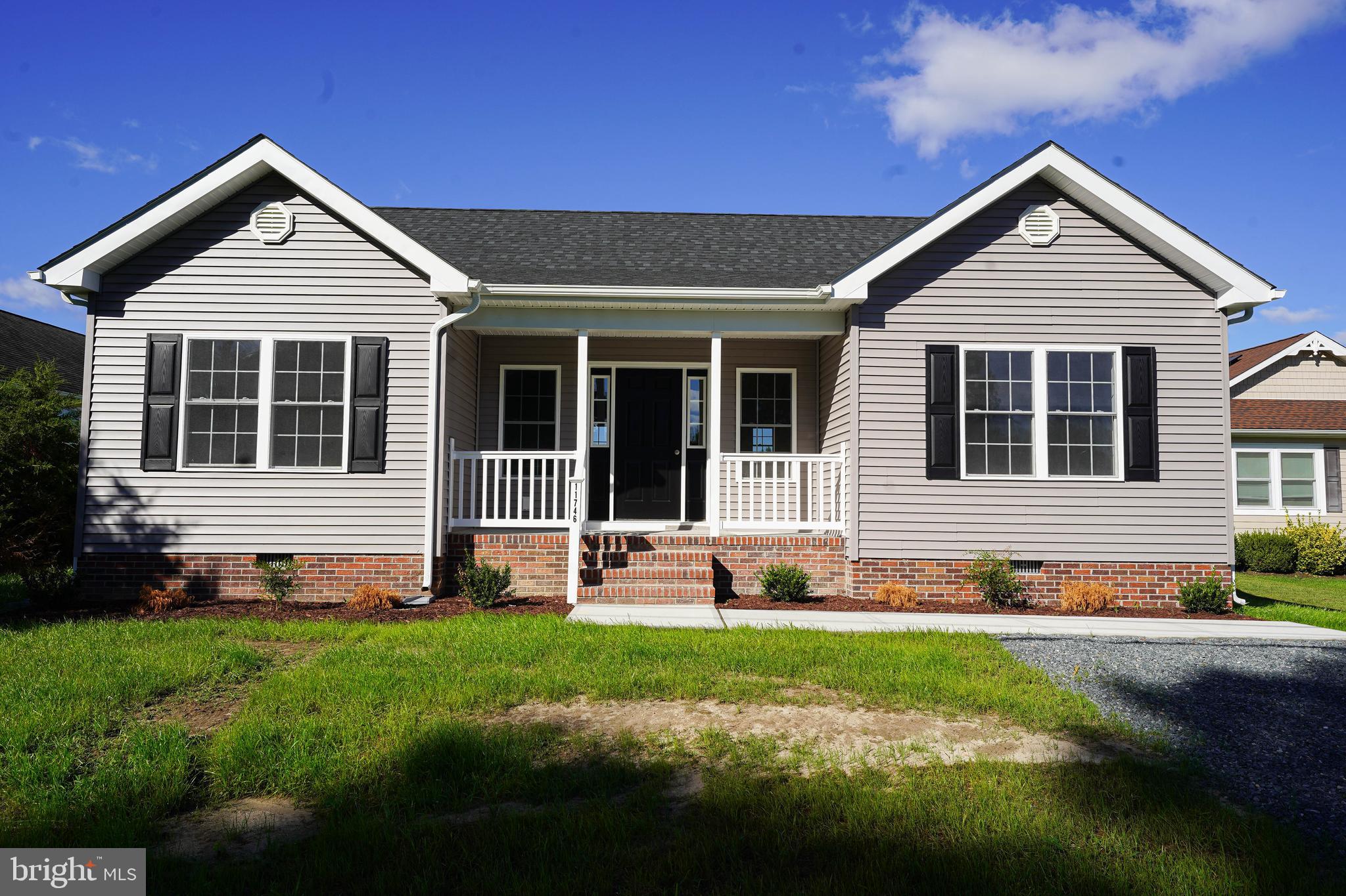 a front view of a house with a yard and potted plants