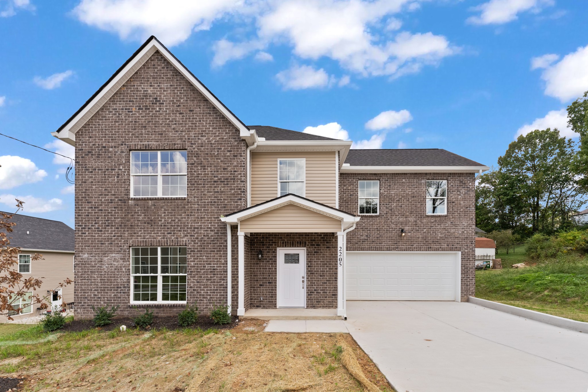 a front view of a house with a yard and garage