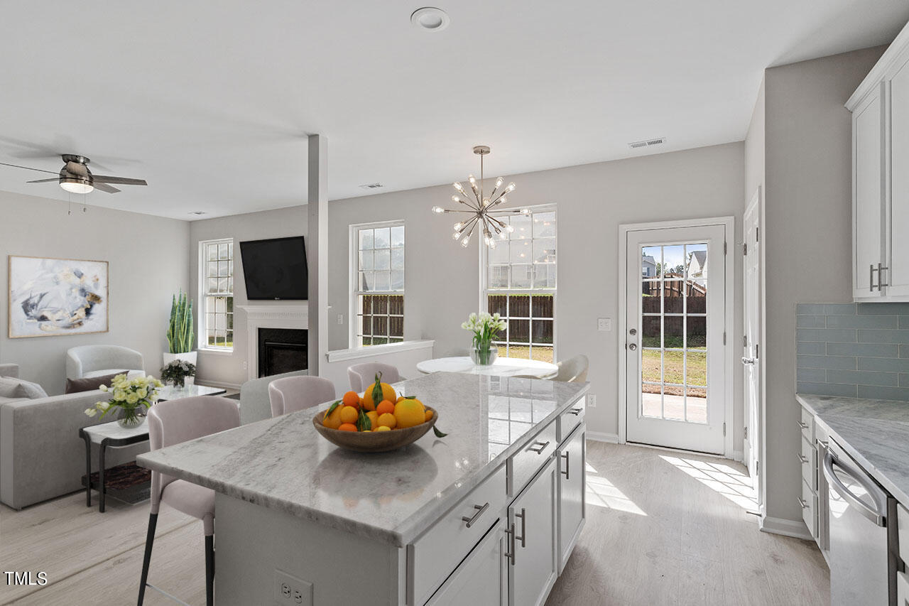 a view of a dining room and a kitchen with a table chairs