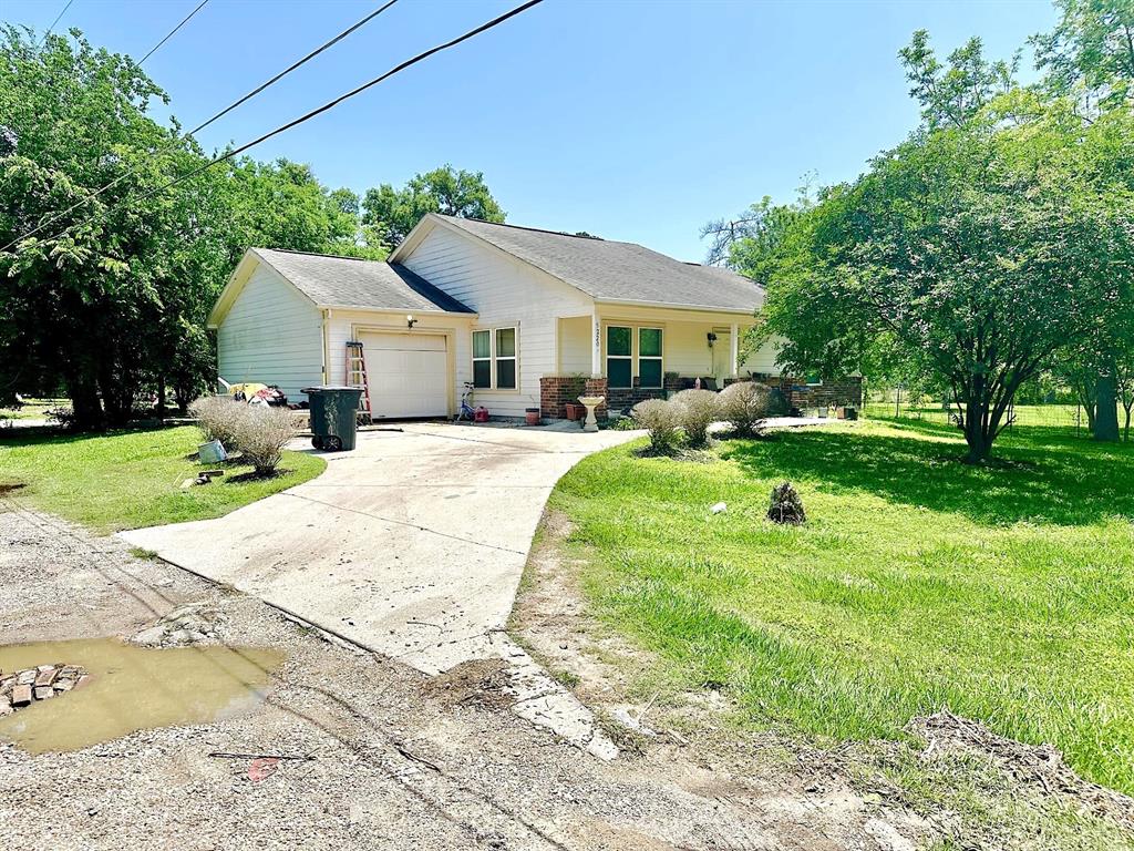 a front view of a house with garden and trees