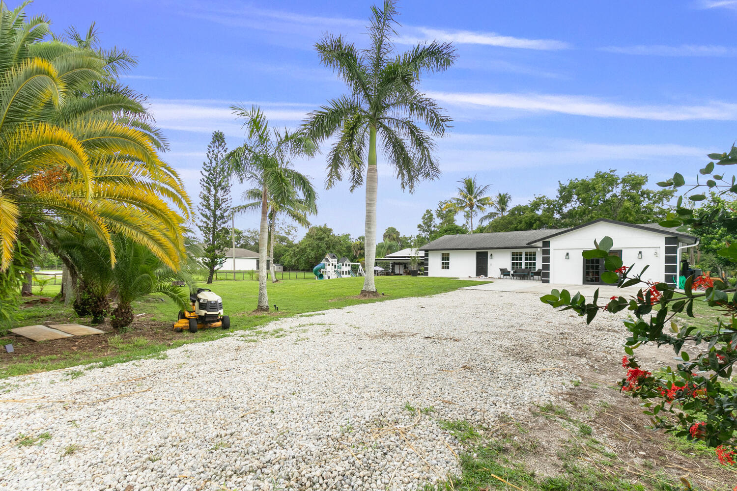 a view of a house with a yard and potted plants