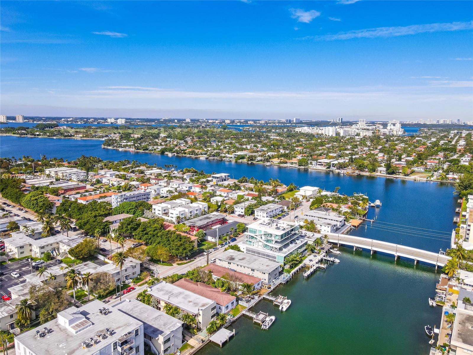 an aerial view of ocean and residential houses with outdoor space