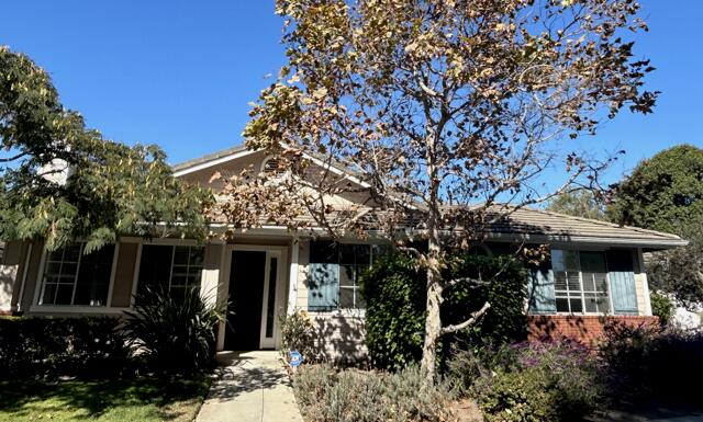 a view of a house with potted plants and large trees