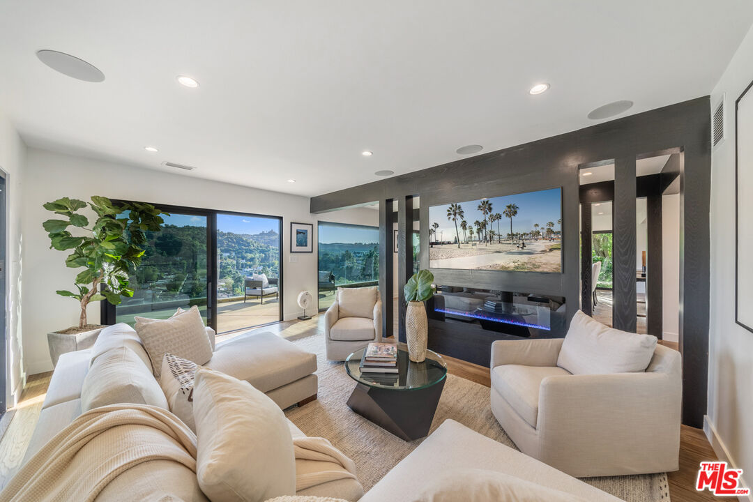 a living room with furniture fireplace and a large window