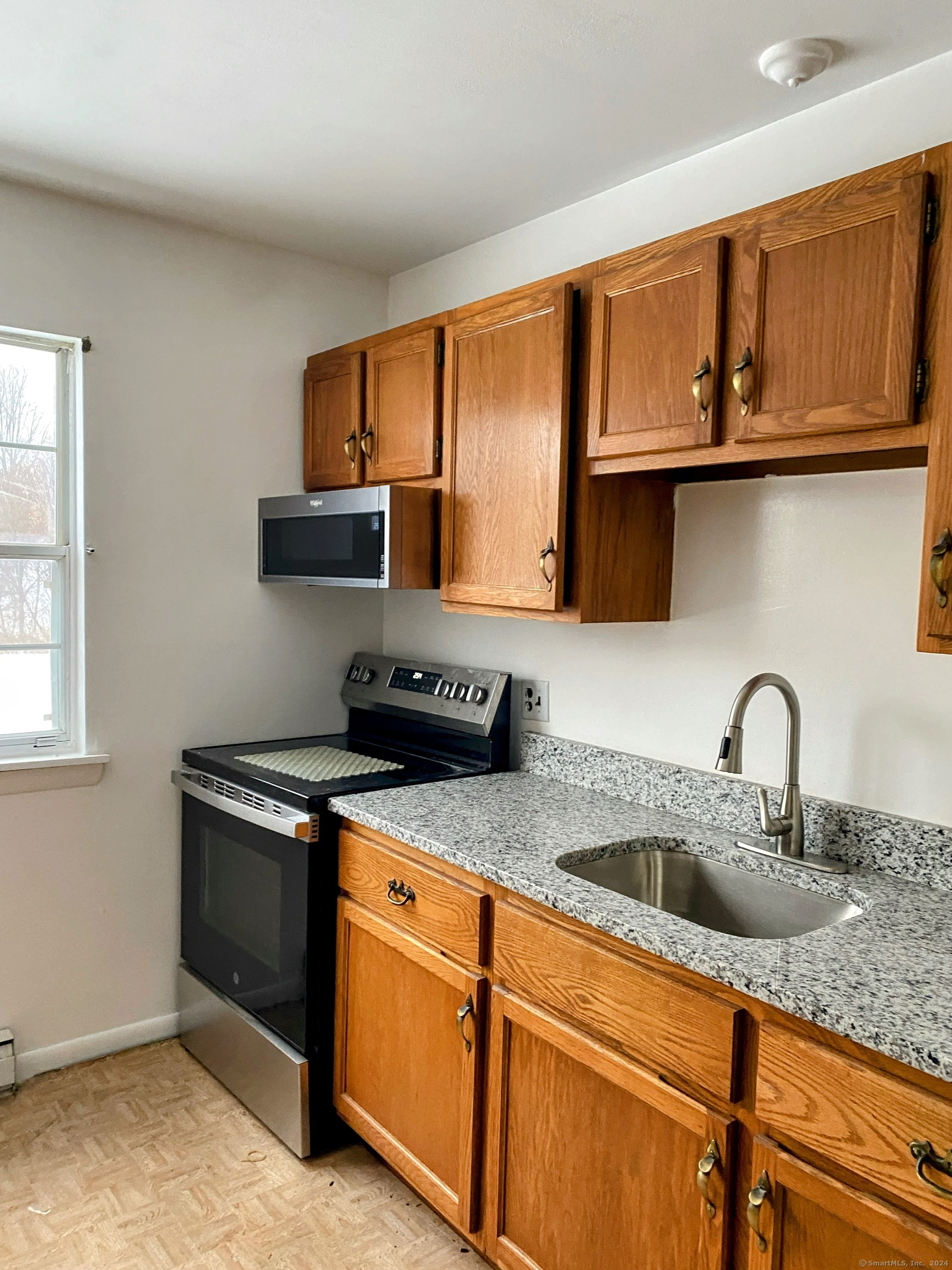 a kitchen with stainless steel appliances granite countertop a sink stove and cabinets