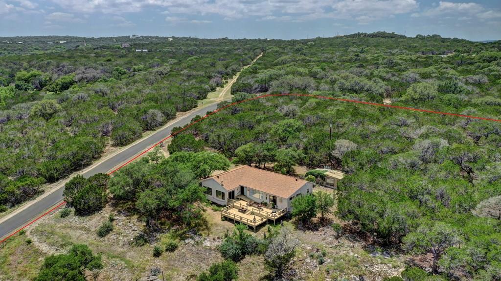 an aerial view of a house with a yard and trees