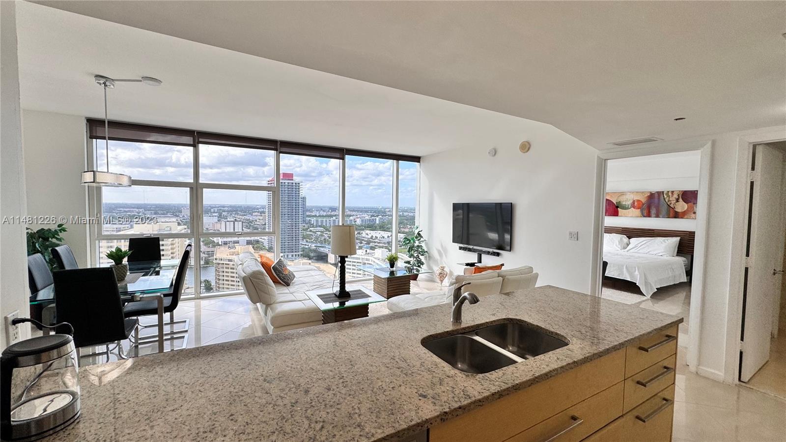 a living room with furniture and floor to ceiling window