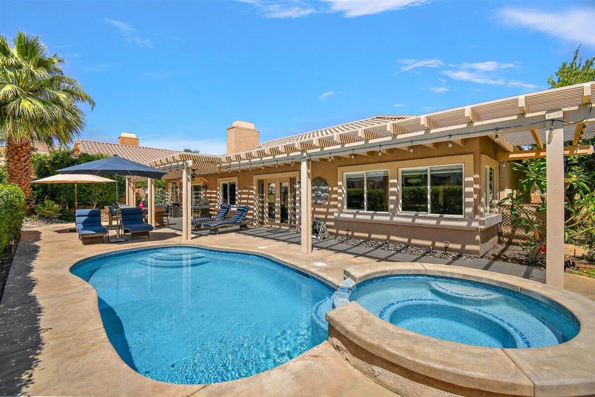 a view of a house with swimming pool and sitting area