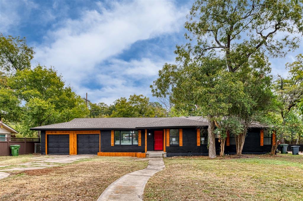 Single story home featuring a garage and a front lawn