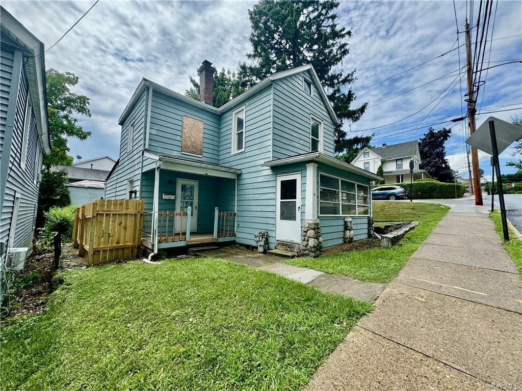 a view of a house with a yard and sitting area