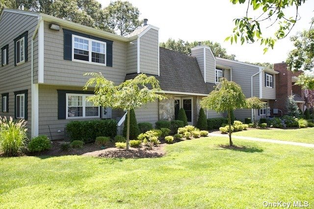 a view of a house with yard and sitting area