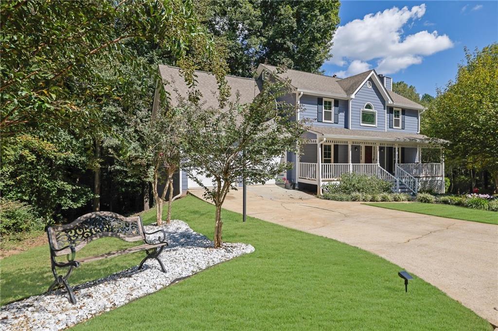 a front view of a house with a yard and trees