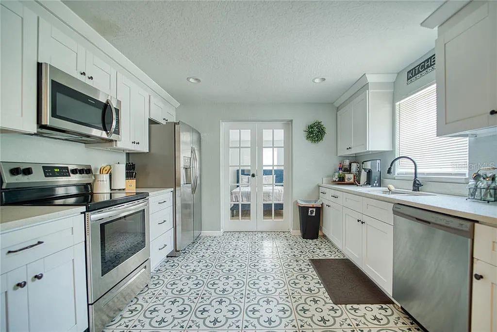 a open kitchen with stainless steel appliances granite countertop a sink dishwasher stove top oven and refrigerator