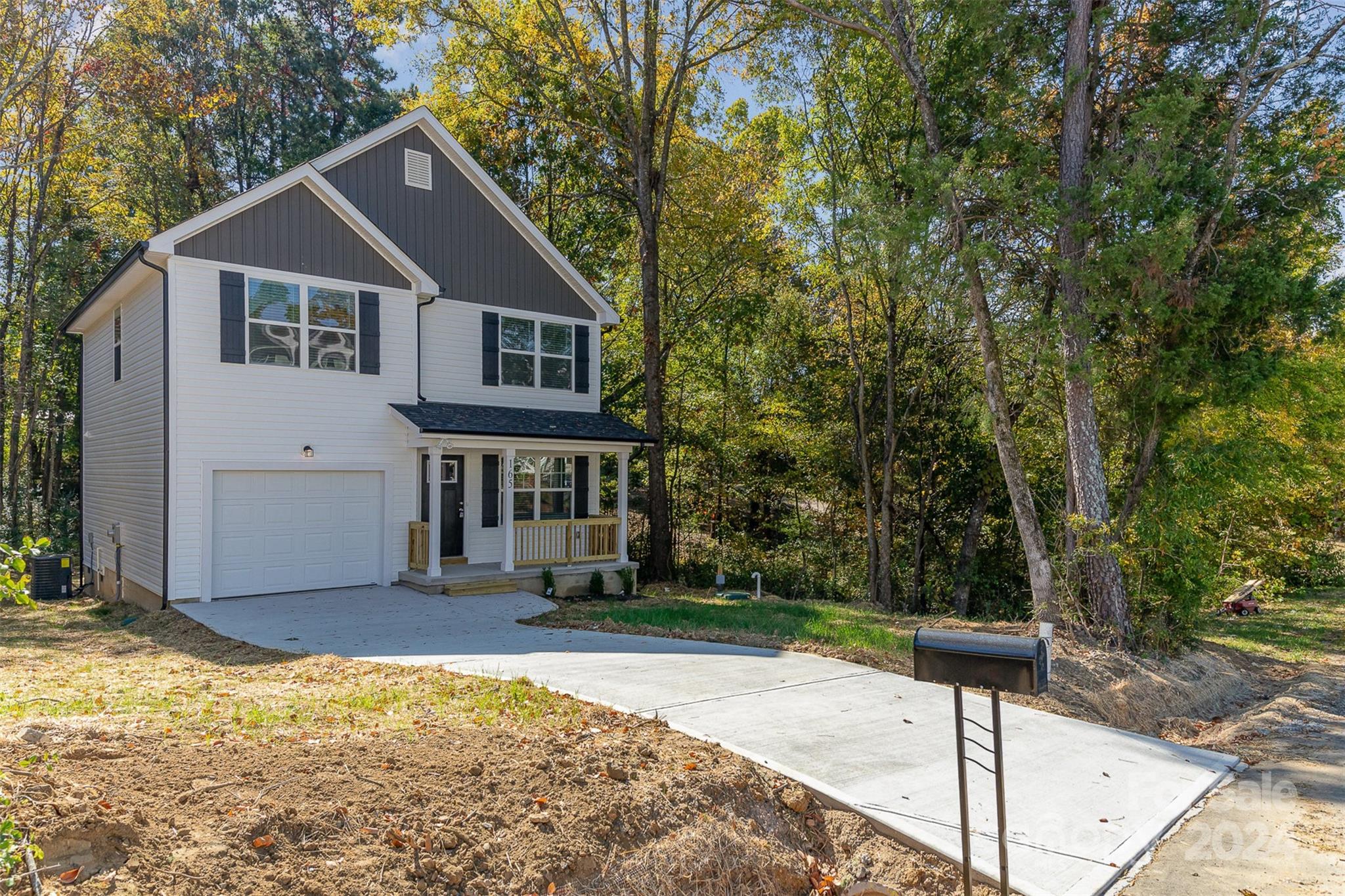 a front view of a house with a yard and trees