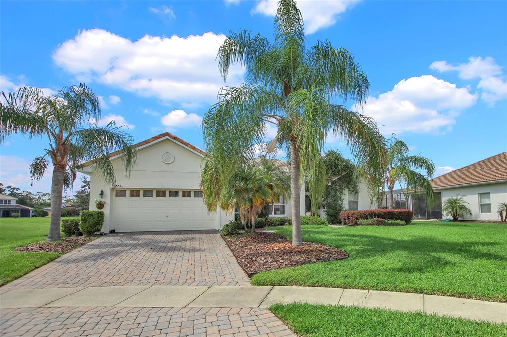 a view of yellow house with palm trees