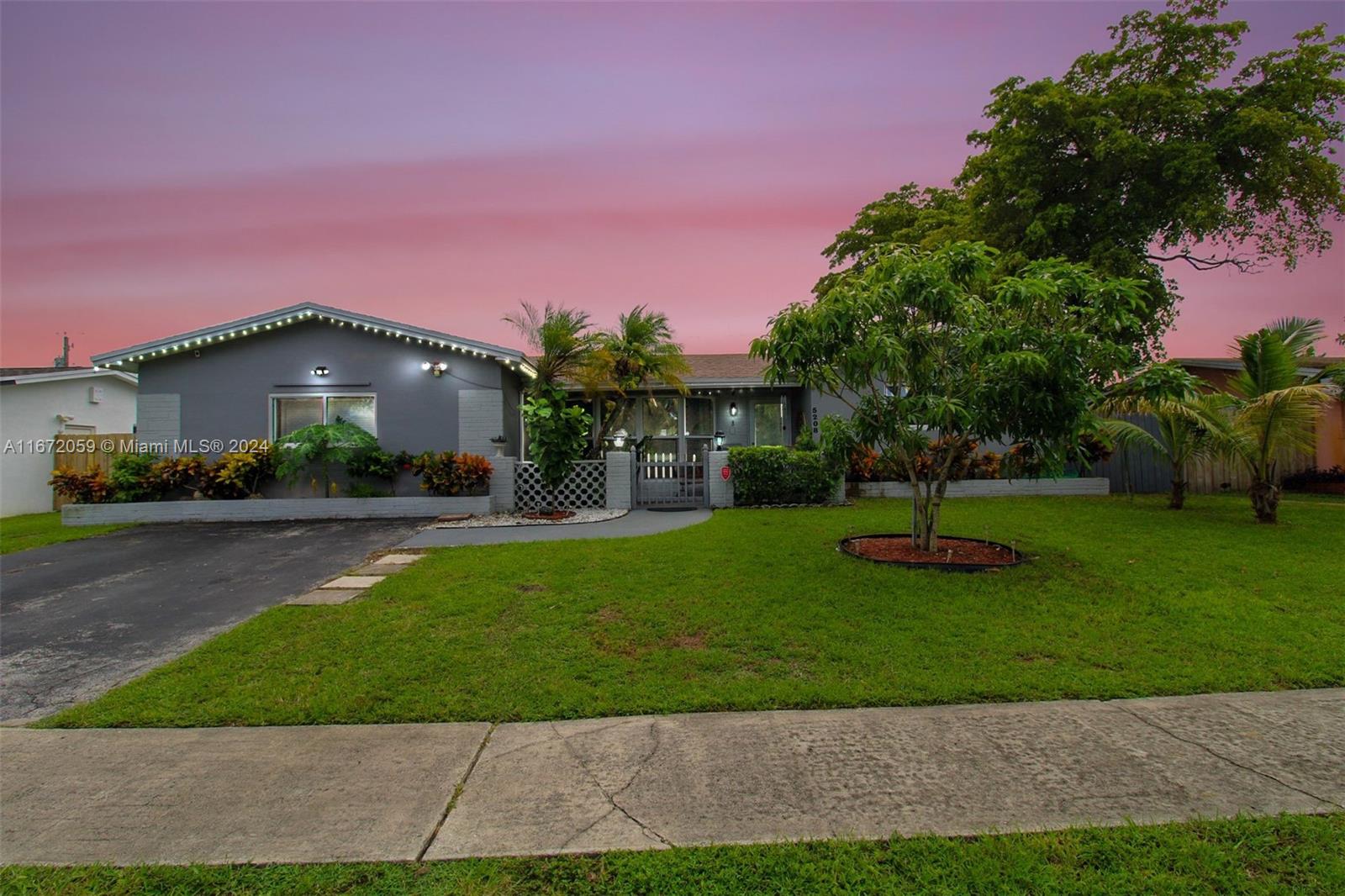 a front view of a house with a yard and green space