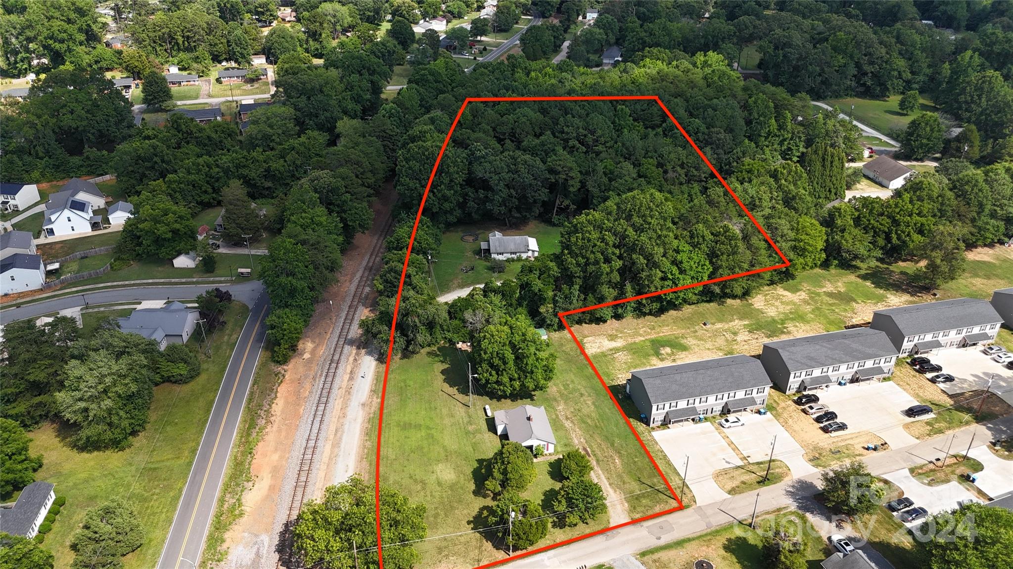 an aerial view of a residential houses with yard