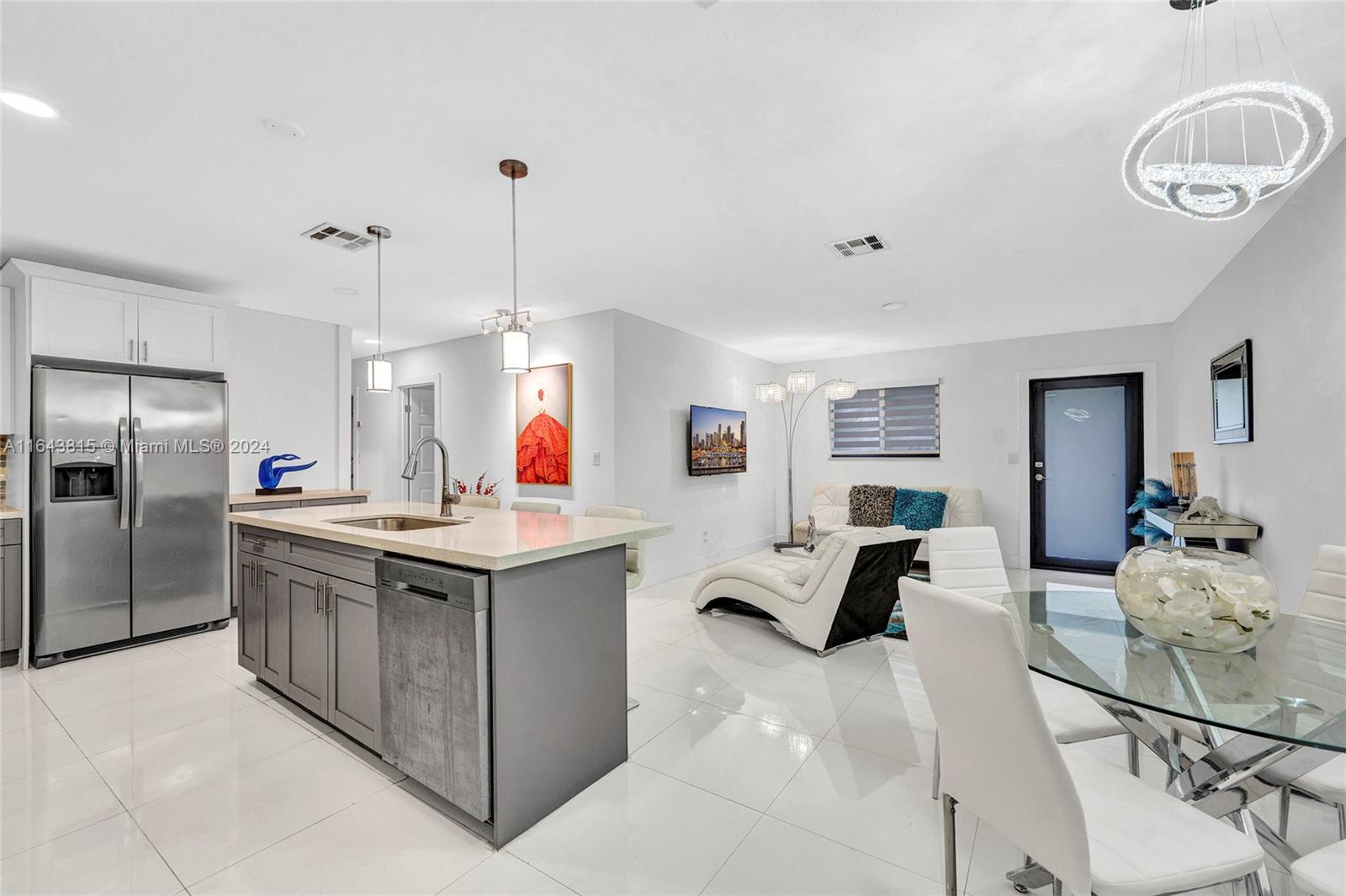 a kitchen with stainless steel appliances kitchen island granite countertop a sink and refrigerator