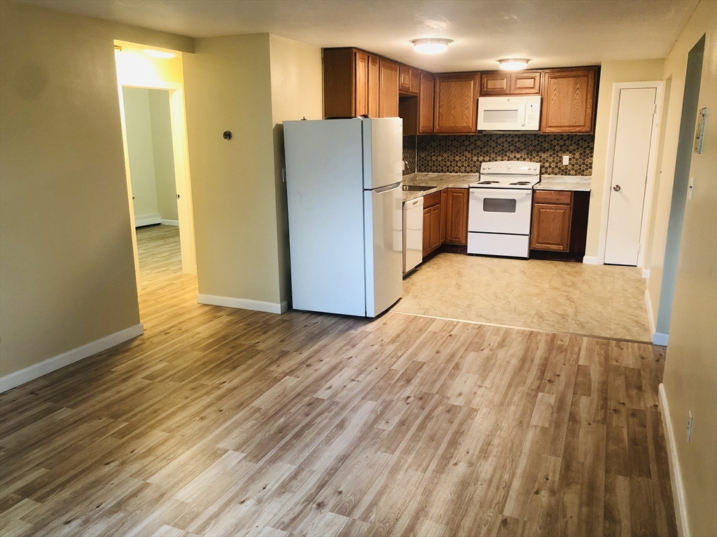 a kitchen with granite countertop a refrigerator and a stove top oven