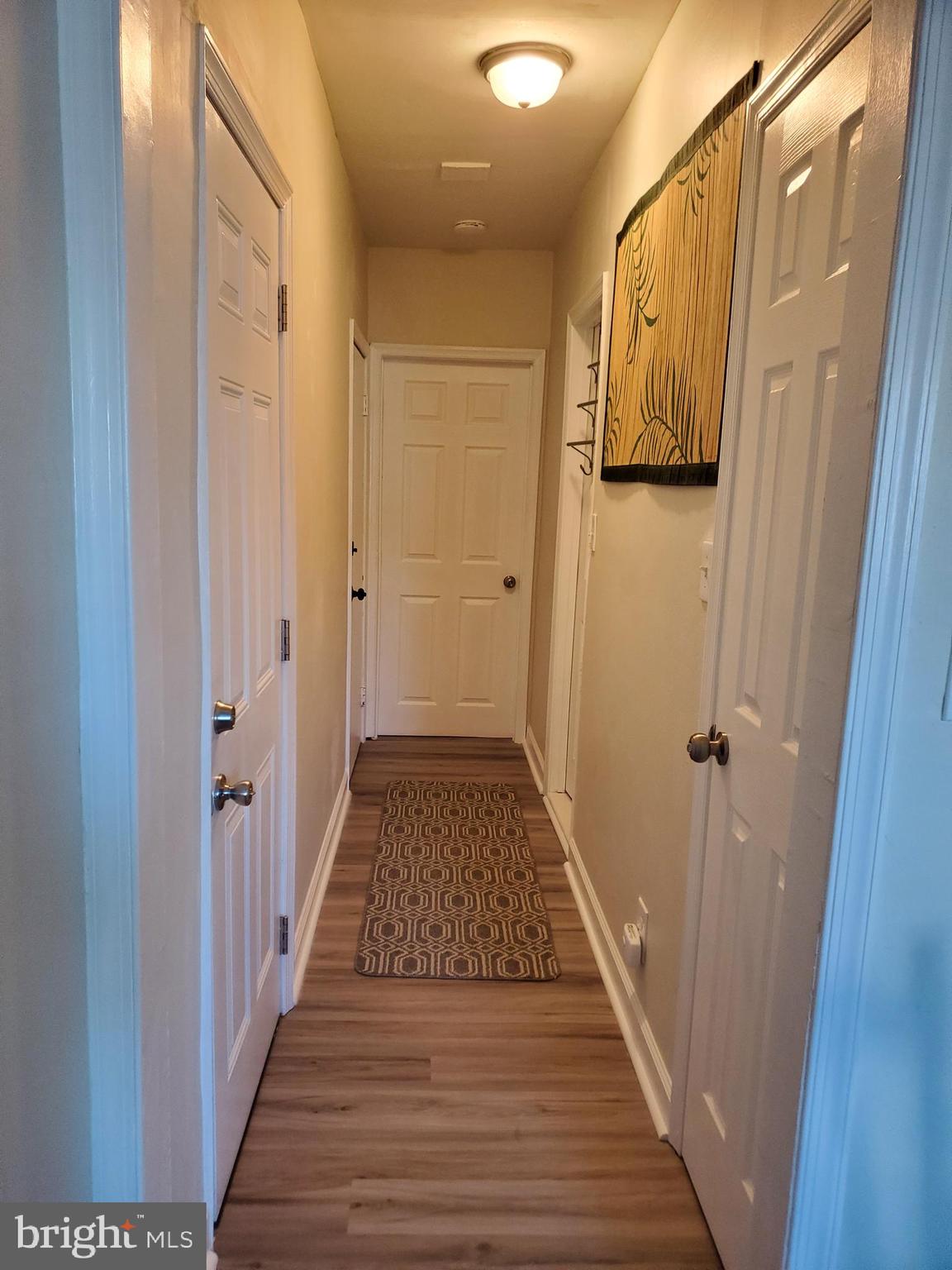 a view of a hallway with wooden floor and staircase