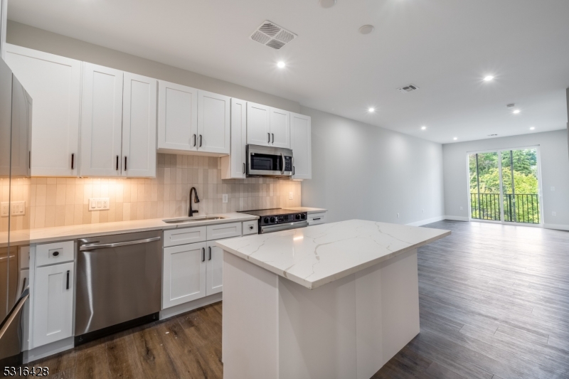 a kitchen with a stove a sink a microwave and cabinets