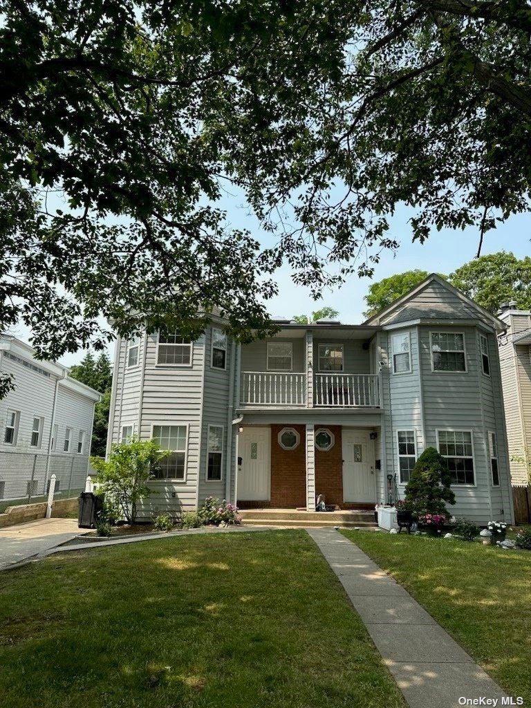 a front view of a house with a garden and plants