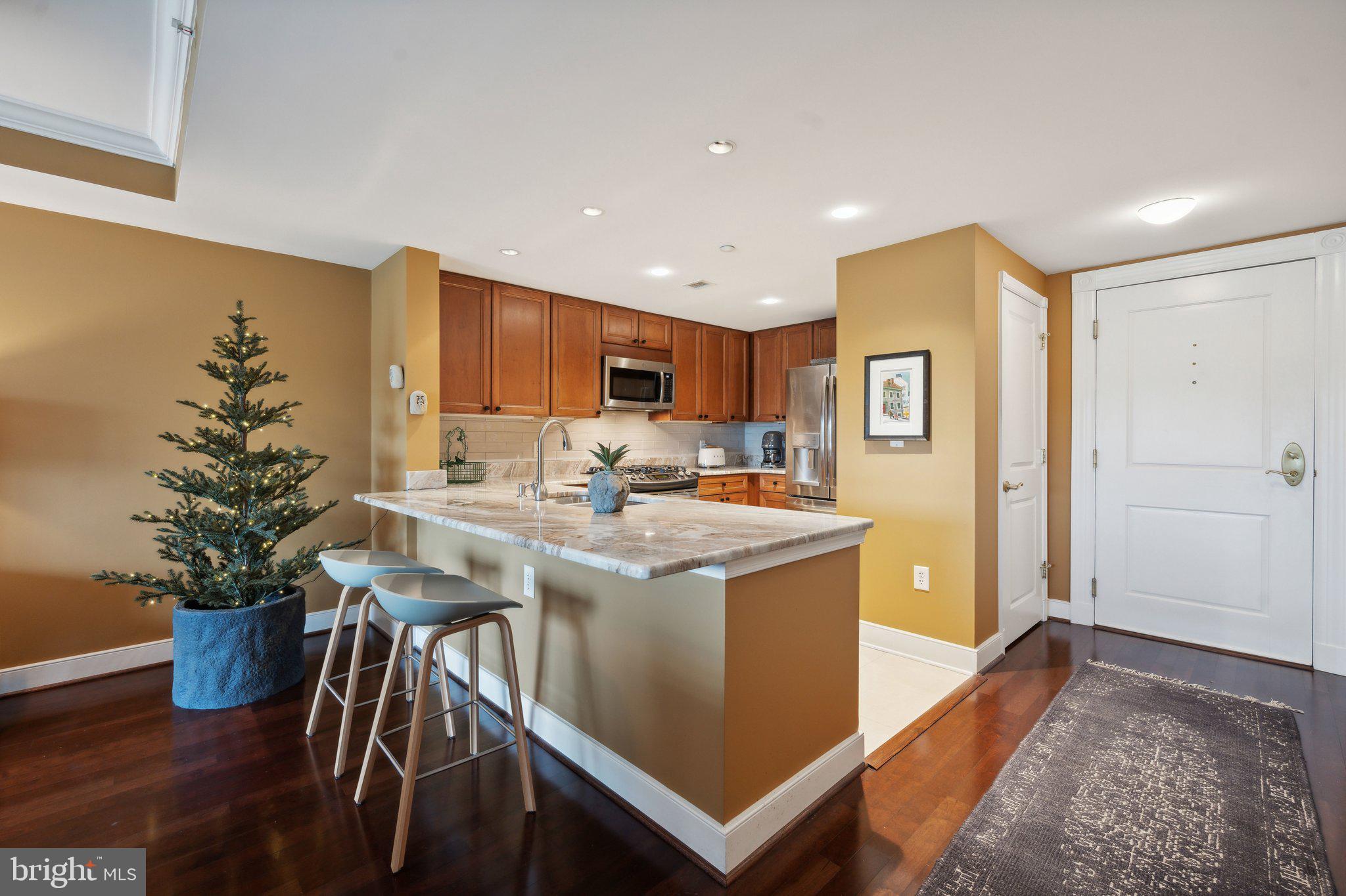 a kitchen with stainless steel appliances granite countertop a sink a stove and a refrigerator