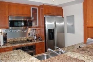 a kitchen with stainless steel appliances kitchen island granite countertop a refrigerator and a stove top oven