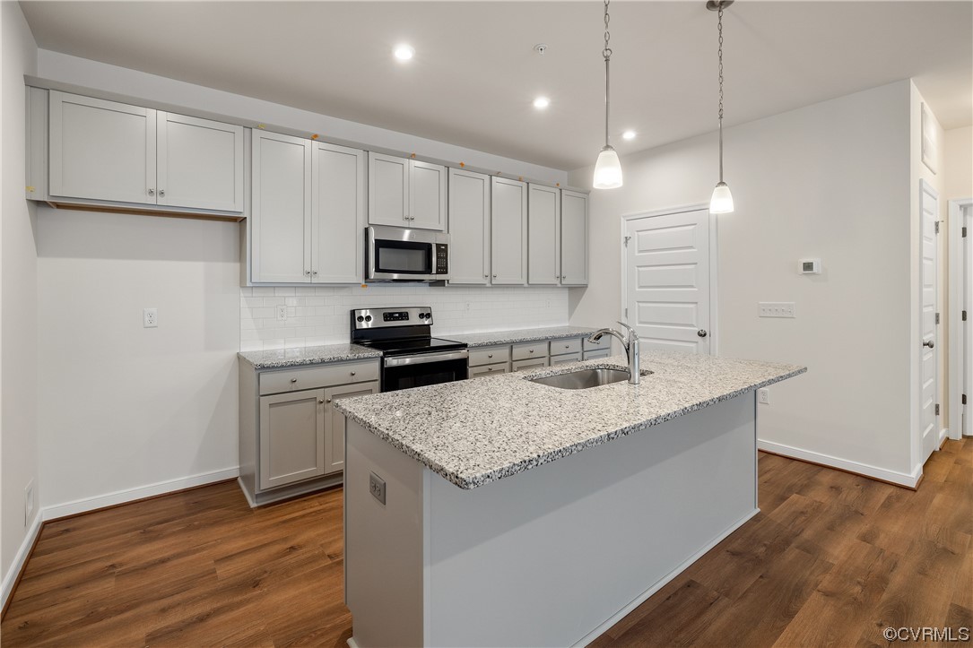 a kitchen with kitchen island a sink stainless steel appliances and cabinets