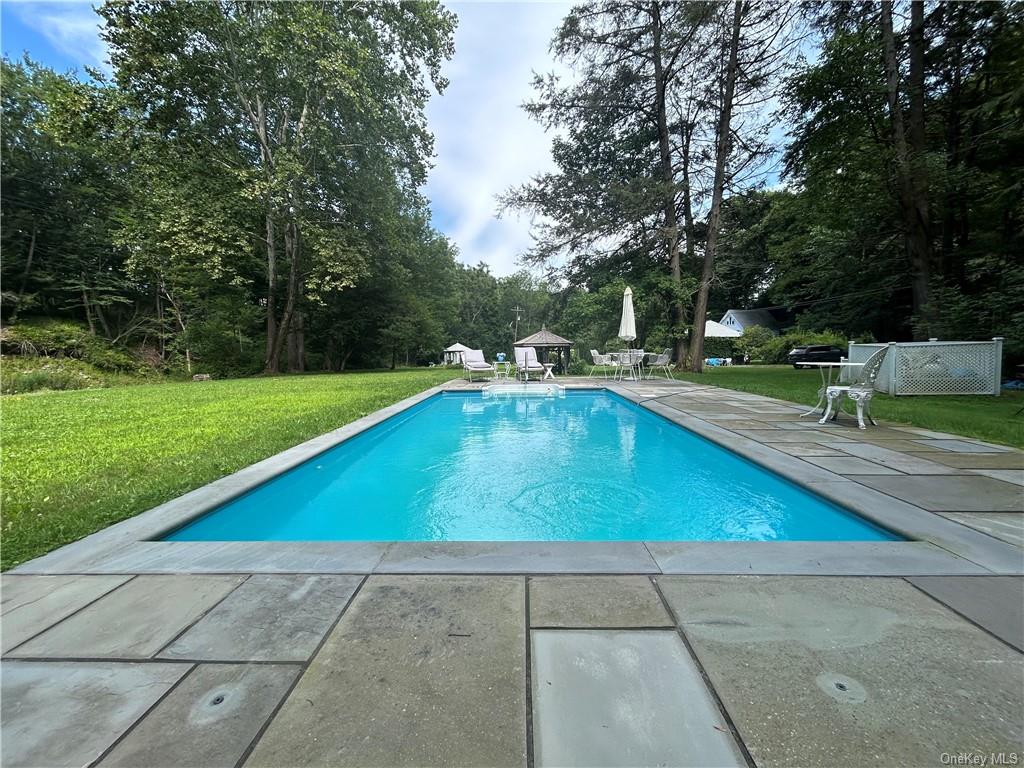 a view of a backyard with a bench and trees