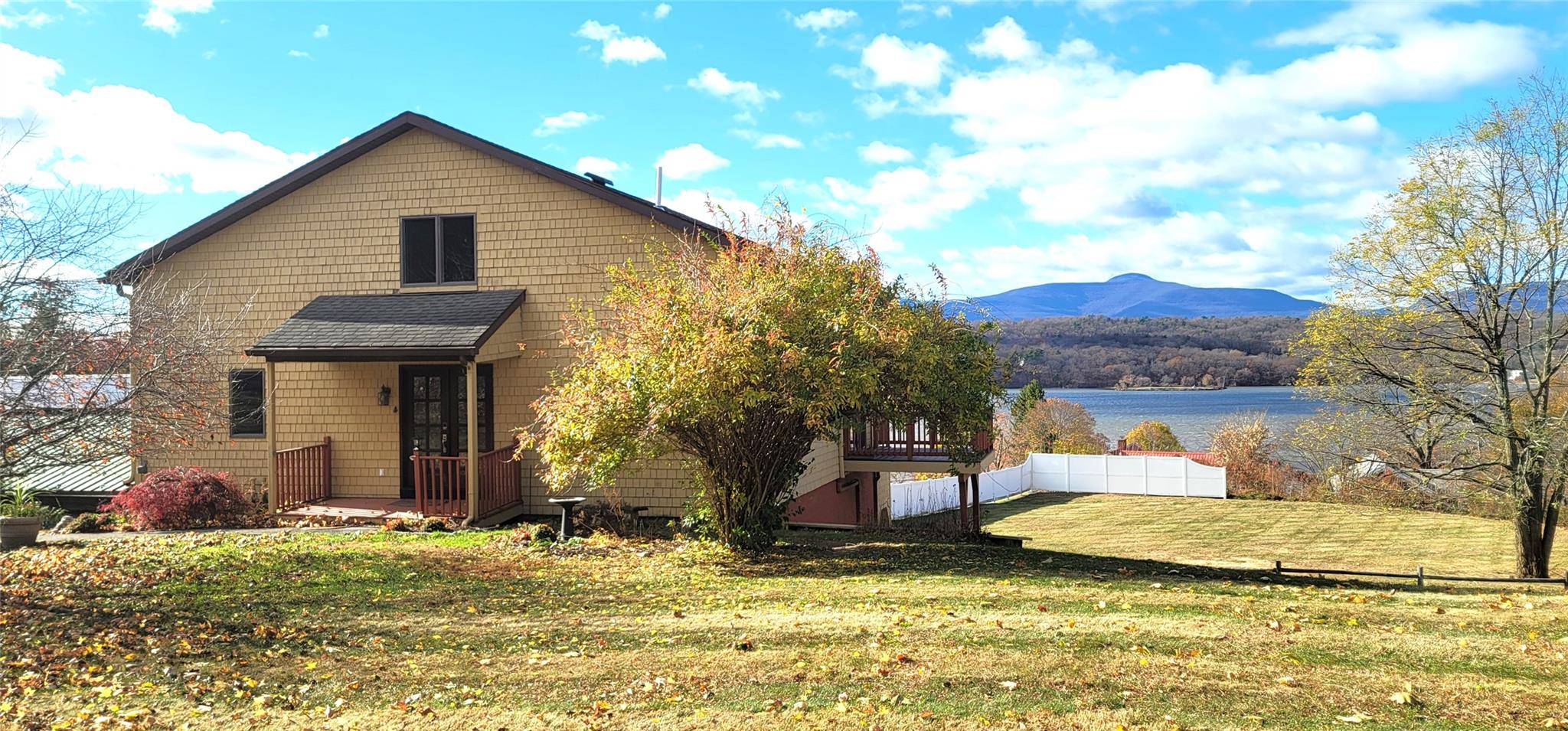 View of front facade with a water and mountain view and a front yard