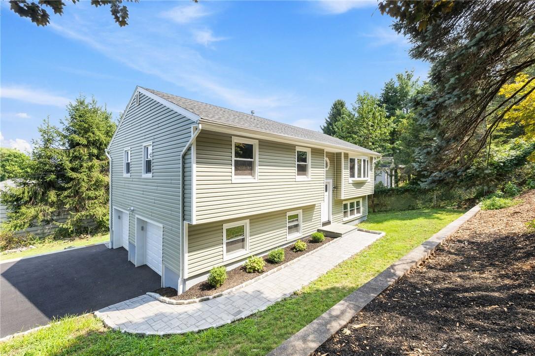 View of home's exterior with a garage and a yard