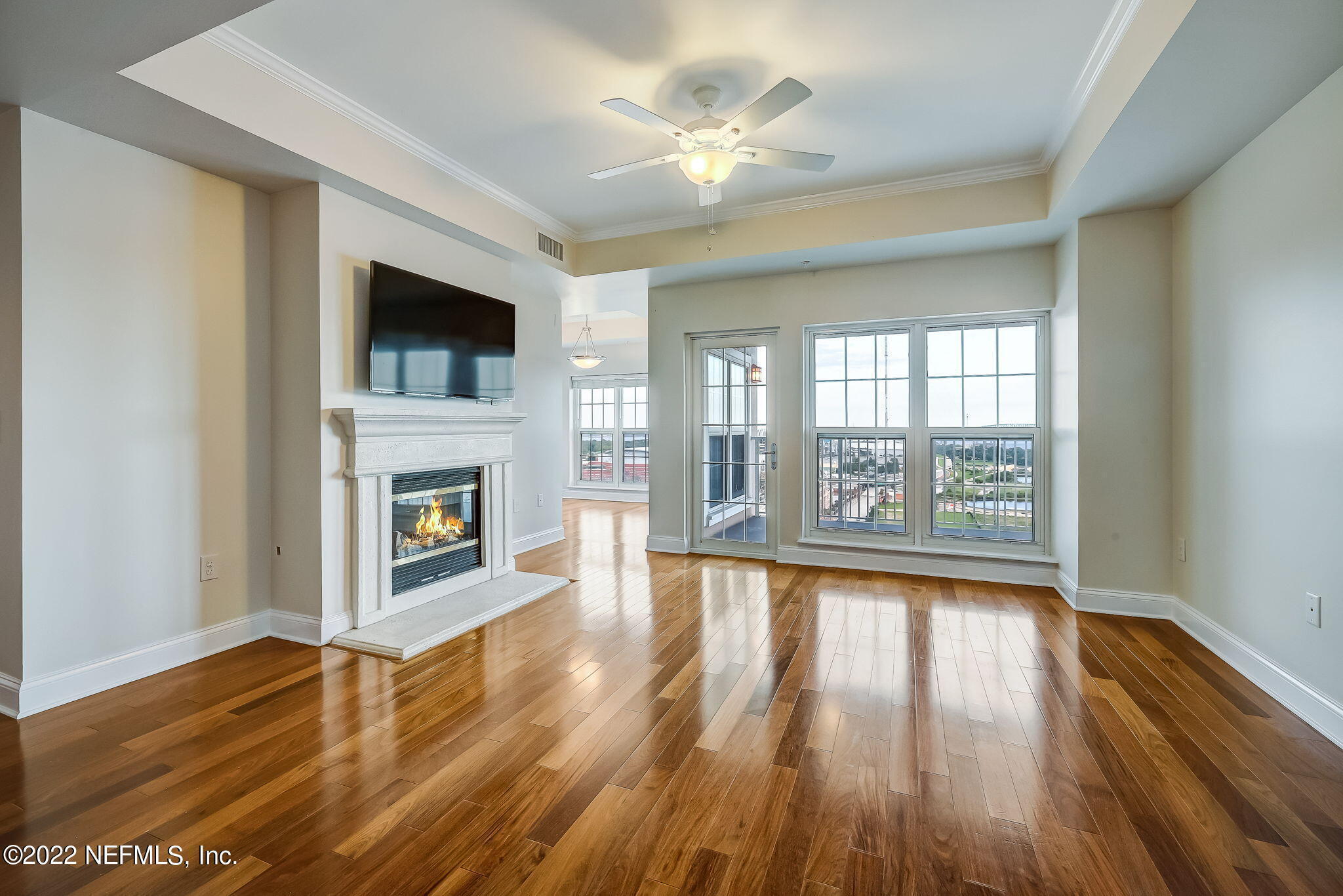 wooden floor fireplace and windows in an empty room