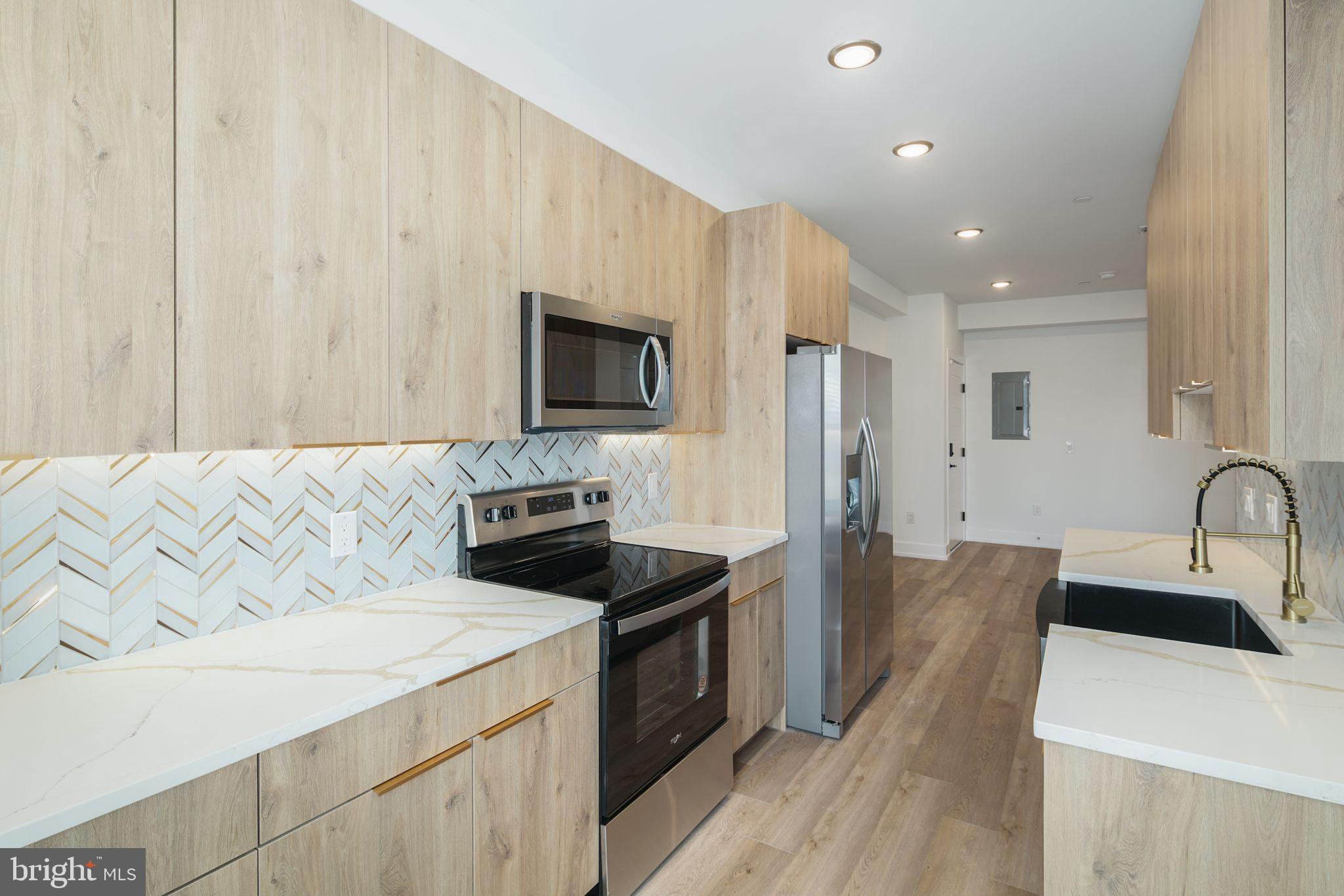 a kitchen with granite countertop a sink stove and refrigerator