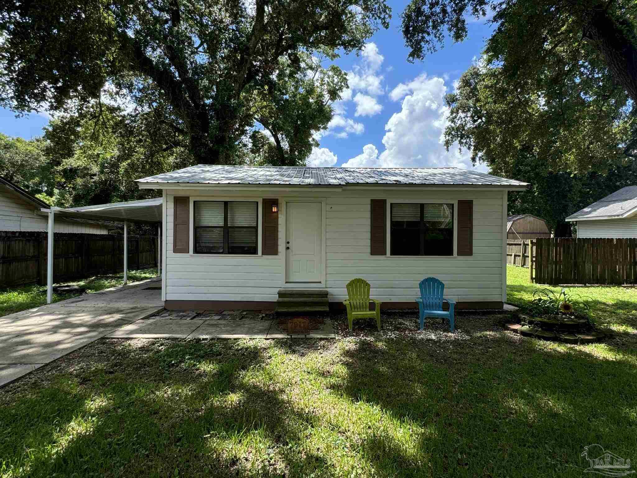 a front view of house with yard and trees in the background